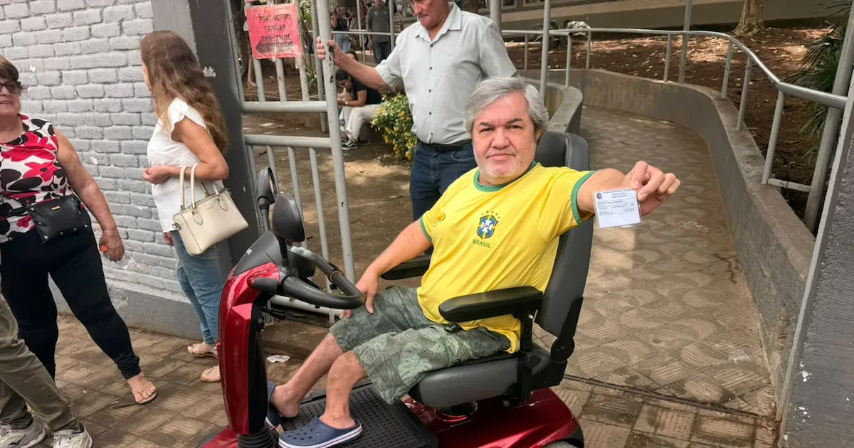 Eleitor cadeirante é carregado até sala de votação em Divinópolis