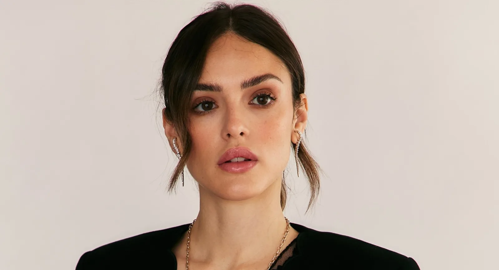 Isabelle Drummond chega a evento da Netflix com look preto e botas marrons